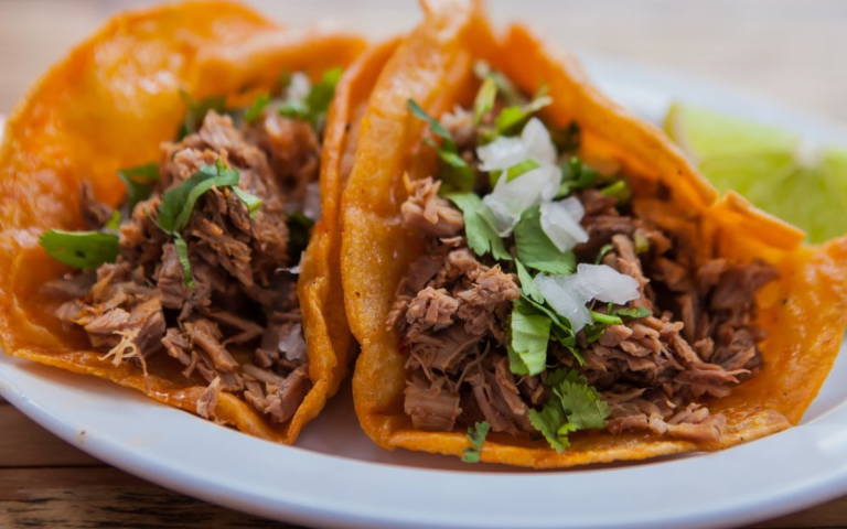 Tacos de birria de chivo con consomé y cilantro fresco